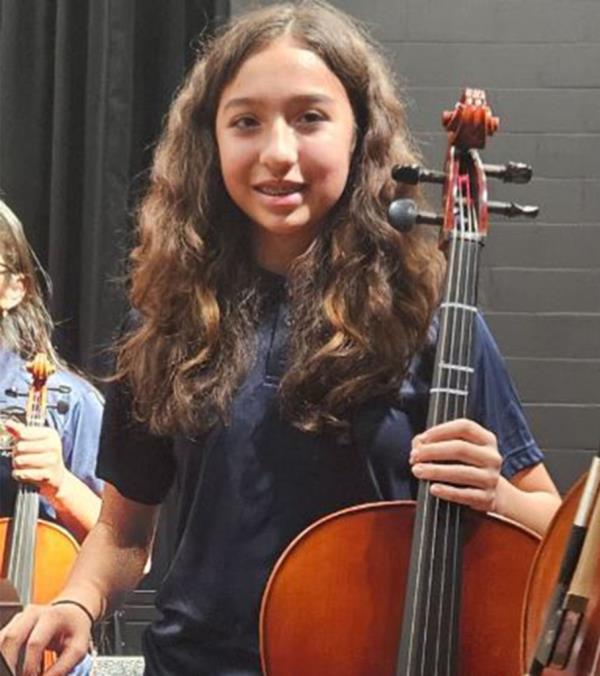 A young Jocelyn Nungaray in a photo with her peers holding a cello.