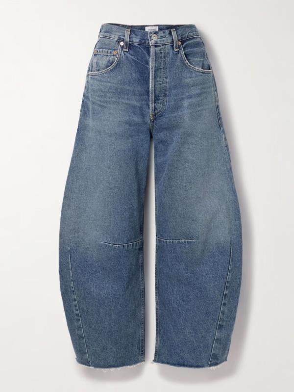 A woman wearing the Luna High Rise Pieced Taper in Void, the season's trendy barrel-leg jeans