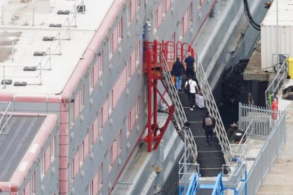 People boarding the Bibby Stockholm accommodation barge at Portland Port in Dorset. The Home Office have said around 50 asylum seekers would board the ship, with the numbers rising to its maximum capacity over the coming months, despite safety co<em></em>ncerns raised by some of the county's Co<em></em>nservative MPs and locals. Picture date: Mo<em></em>nday August 7, 2023. PA Photo. See PA story POLITICS Migrants. Photo credit should read: James Manning/PA Wire