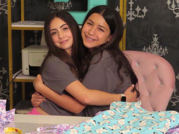 Sisters Audrina and Giuliana Demma hugging at their home sewing station, wher<em></em>e they produce and do<em></em>nate hospital gowns for sick children